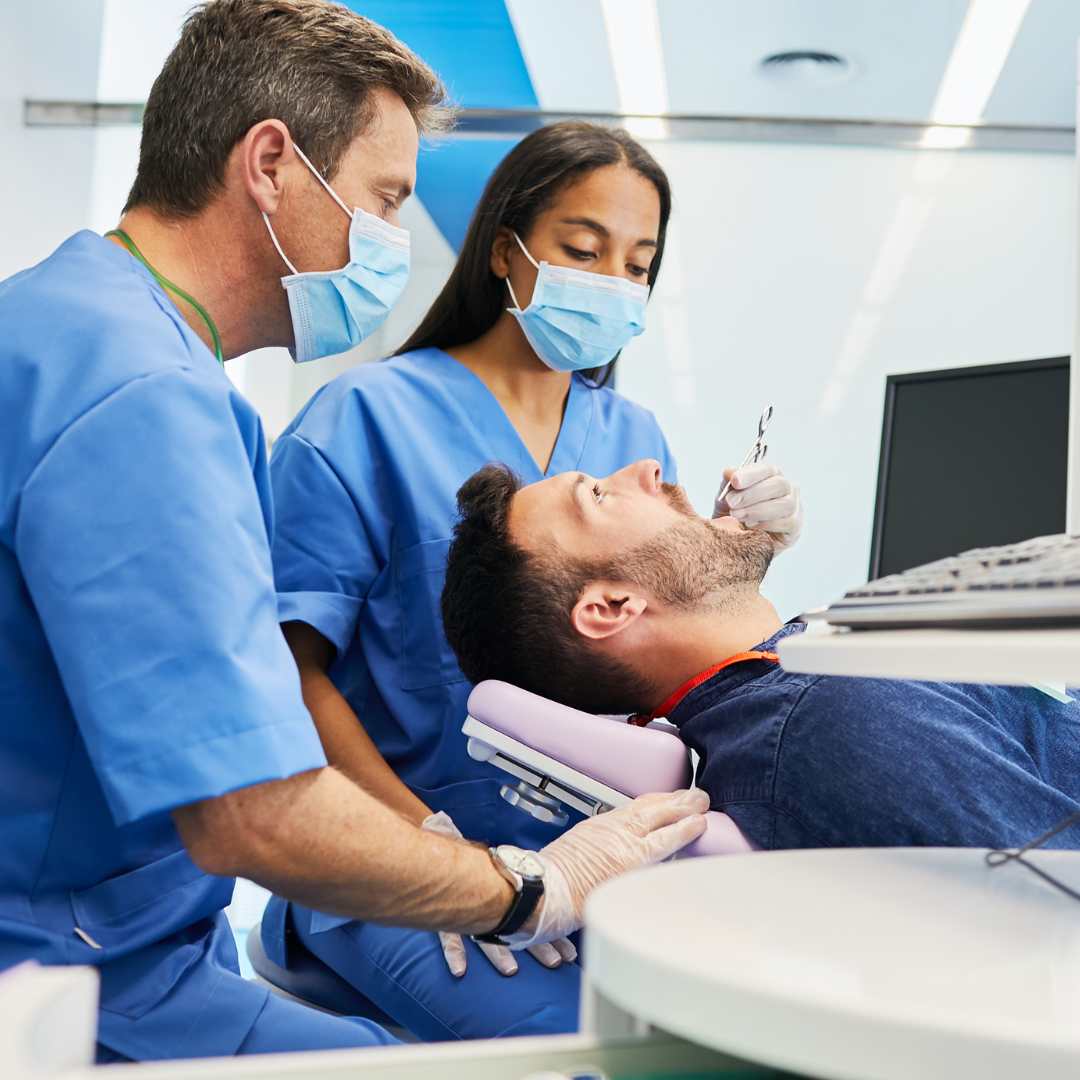Dental professionals performing implant surgery
